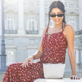 Mujer con vestido rojo posando sentada en un punto turístico de Madrid