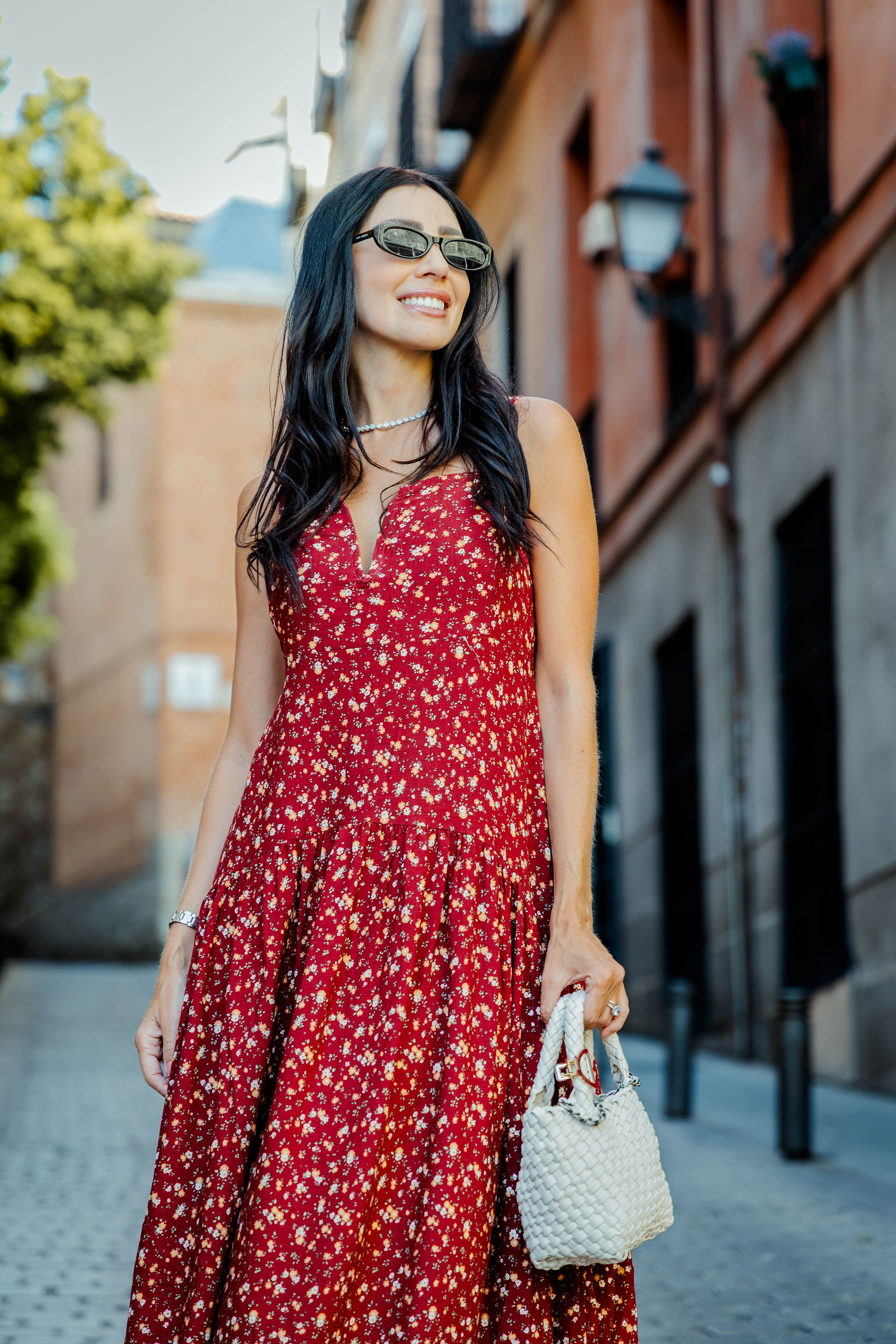 Mujer con vestido largo floral rojo en una calle de Madrid