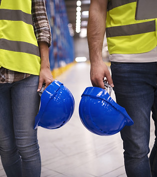 two-unrecognizable-workers-reflective-suit-walking-through-warehouse-holding-blue-protecti