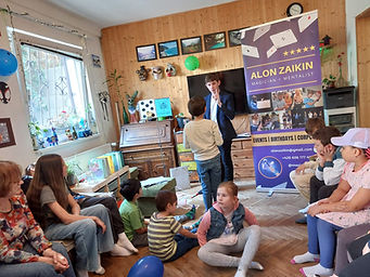 Magician Alon Zaikin entertaining several children at a birthday party