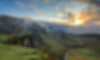 Pathway leading through mountains towards the sunrise.