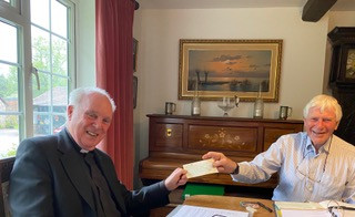 Father John Caperon receiving a cheque from Richard Thorne one of the Trustees of the Friends of Christ Church