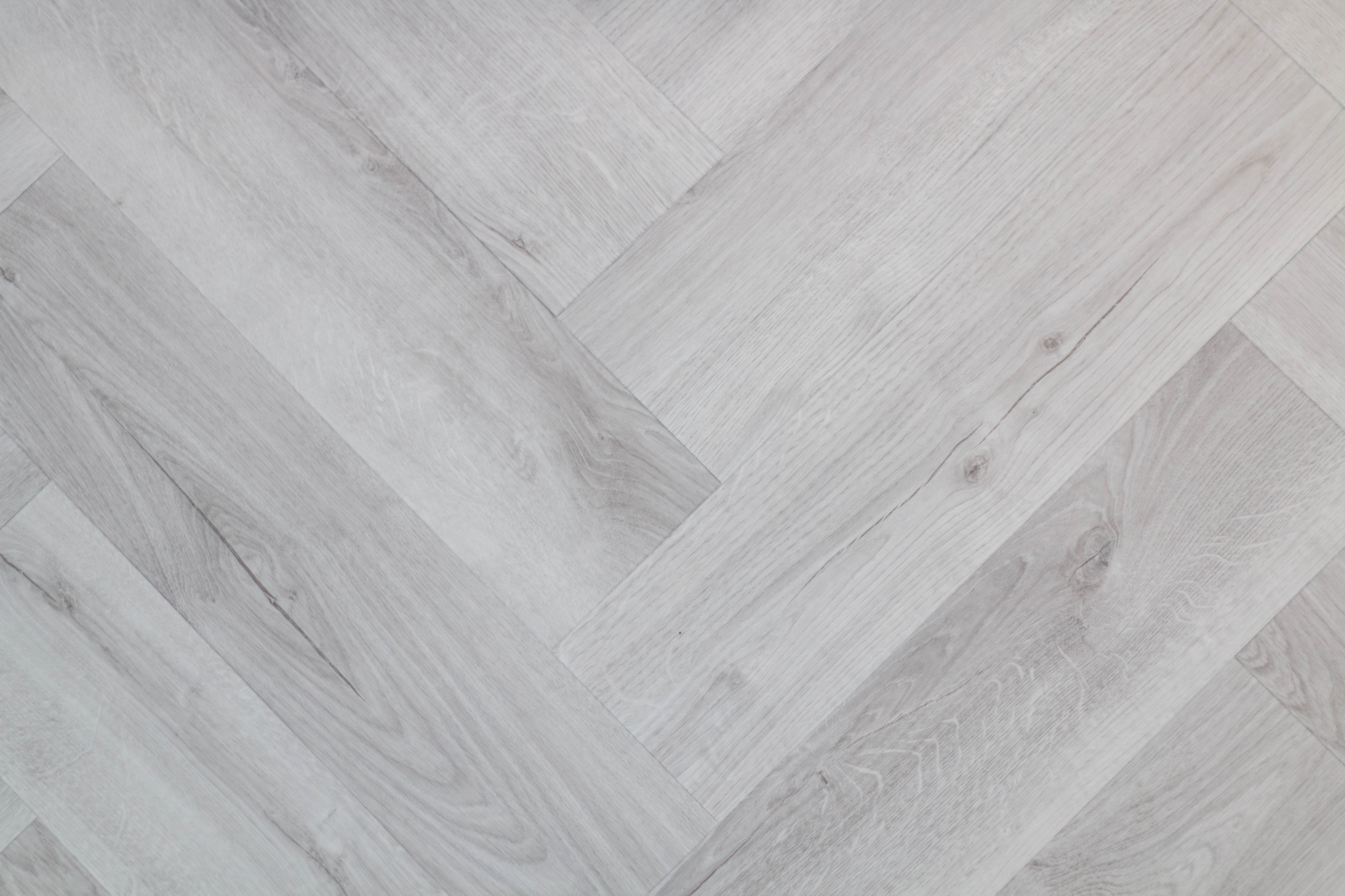 A light, white/grey washed wood effect floor in a herringbone pattern