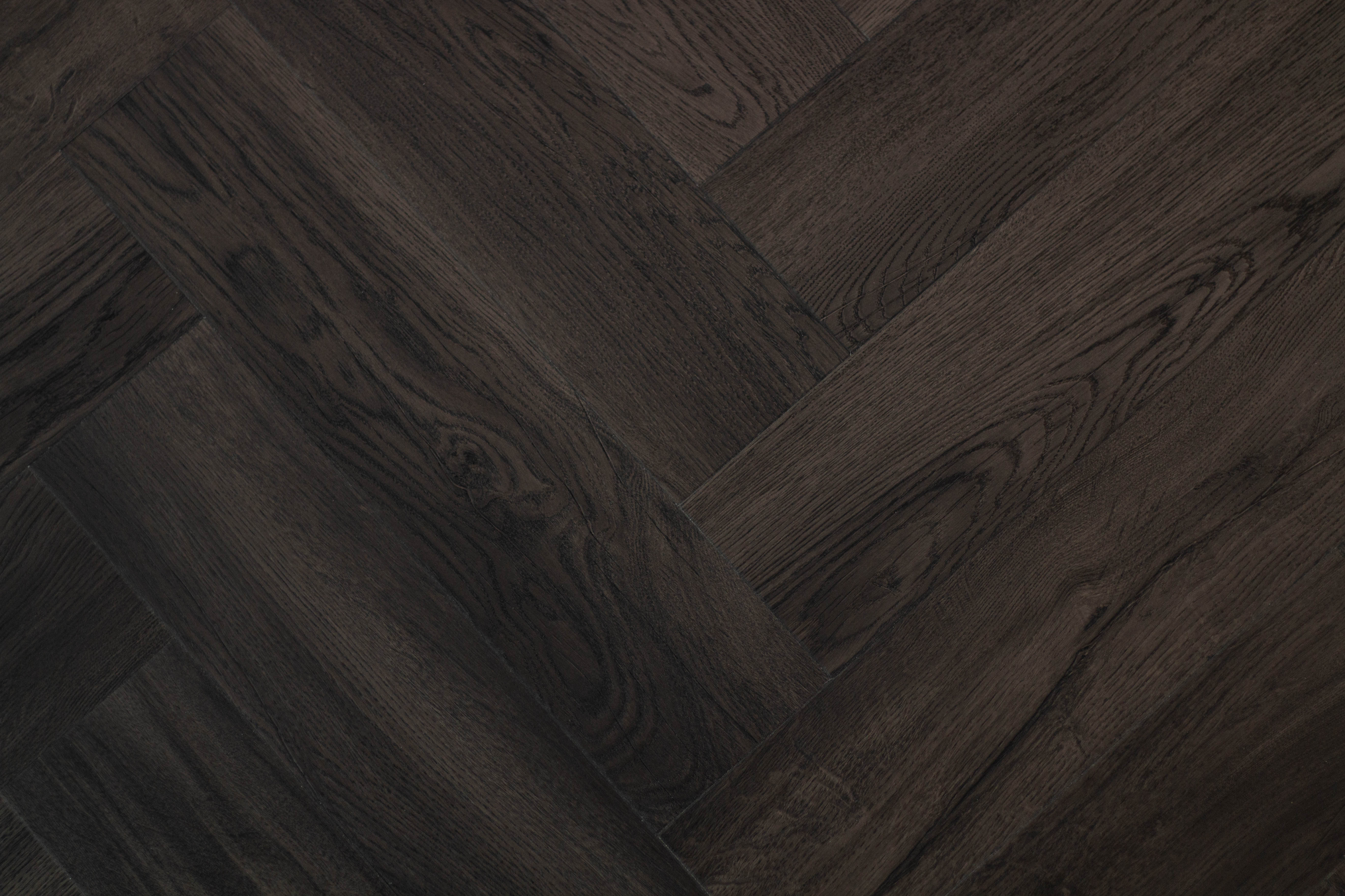 A very dark wood effect floor in a herringbone design