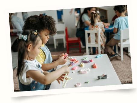 Preschoolers sitting at table playing with clay