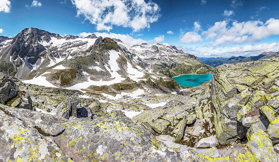 Panorama-Blick vom Anstieg zur Hochfürleg auf den türkisblauen Weißsee, die Staumauer und die Rudolfshütte in den Hohen Tauern.