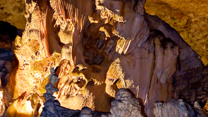 Das erste Bild zeigt eine beeindruckende Formation von Stalagmiten, die durch gezielte Beleuchtung in Szene gesetzt sind.