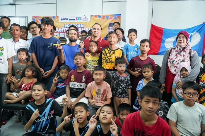 Datuk Farhan bersama kanak kanak sekolah dalam program gunting rambut di Pusat Komuniti MADANI