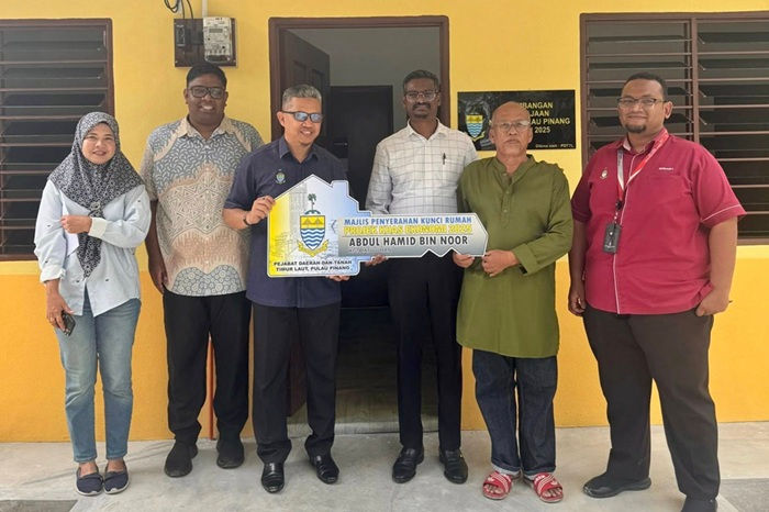 Abdul Hamid (berbaju hijau) menerima replika kunci rumah baharu