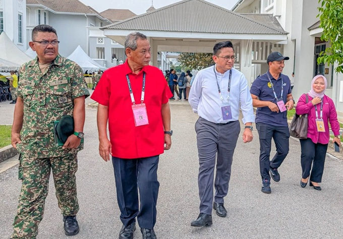 Calon DUN Linggi DS Aminuddin (baju merah) melawat tempat pembuangan undi awal di Port Dickson