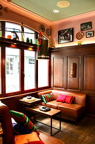 Gemütliche Raucher-Lounge mit Ledercouch und bunten Kissen