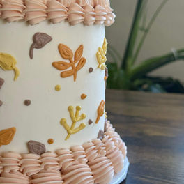Halloween cake with autumn leaf decorations and piped frosting