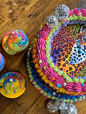 Colorful cake with a leopard print design and several cupcakes on display.