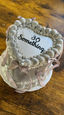 Heart-shaped cake with text reading "30 Something" on a wooden table.
