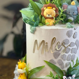 Birthday cake with green leaves and the name Miles. Happy Birthday kids cakes