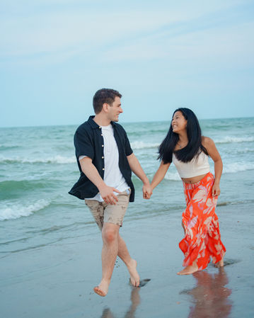 Couple walking together on beach holding hands