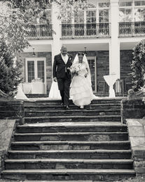 Bride and groom walking down steps in black and white photo.