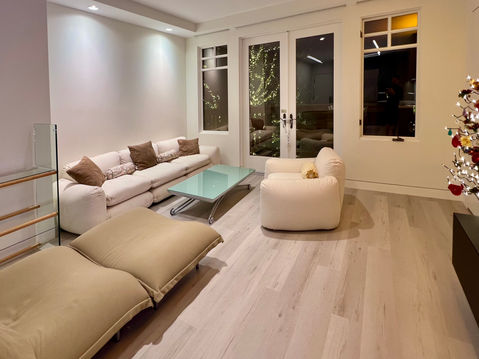 A closer look at the living room's soft seating and full-height windows, which maximize the limited natural light. The alcove for the sofa was custom-designed for this space.