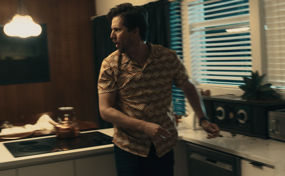 Ellis turns and snaps angrily in the kitchen