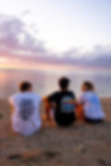 3 friends enjoying a sunset with the oceanic origins t-shirt.