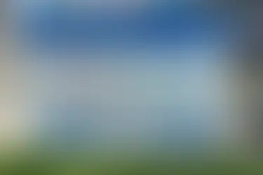 Neurodivergent Communication Board outdoors on grass, features icons and text. Blue header with North Ayrshire Council logo. Rural setting.