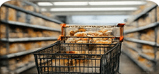 Shopping cart filled with grocery items in a supermarket aisle, representing professional grocery shopping, order fulfillment, warehouse club sourcing, and retail product selection for local grocery delivery, pickup services, Smart Portions™, and Grocery Bundles.