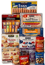 Assorted Costco multipack items including refrigerated products like hummus cups and sliced lunch meat alongside shelf-stable snacks, arranged together to represent a mixed grocery offering.
