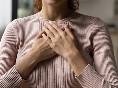 a woman with her hands over her heart