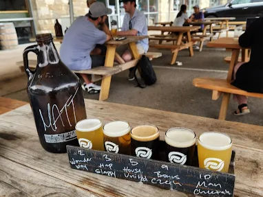 Dog friendly brewery patio with outdoor seating and beer flight sampler on table