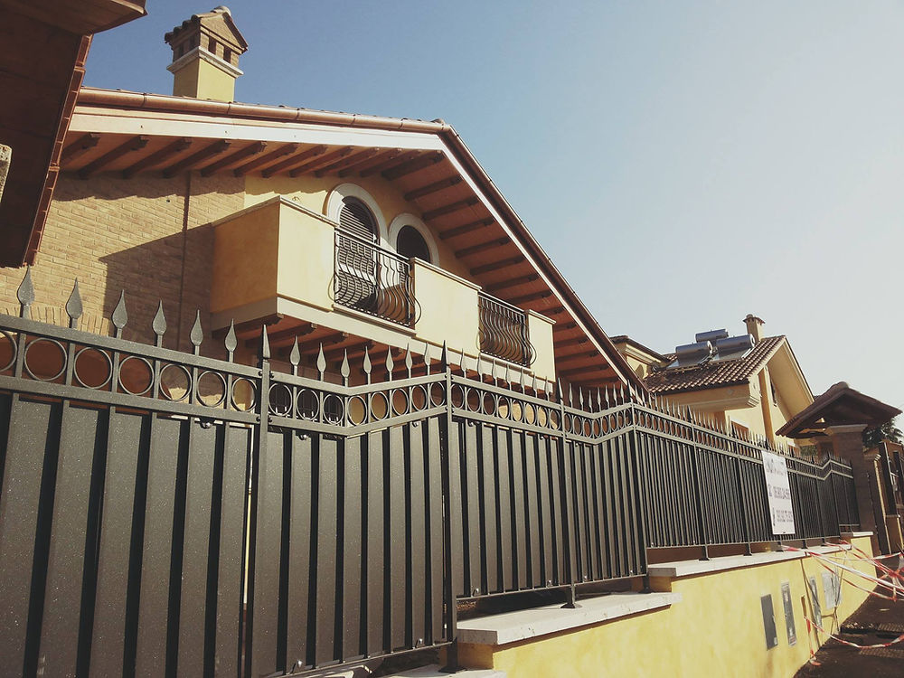 Recinzione metallica scura davanti a una villa