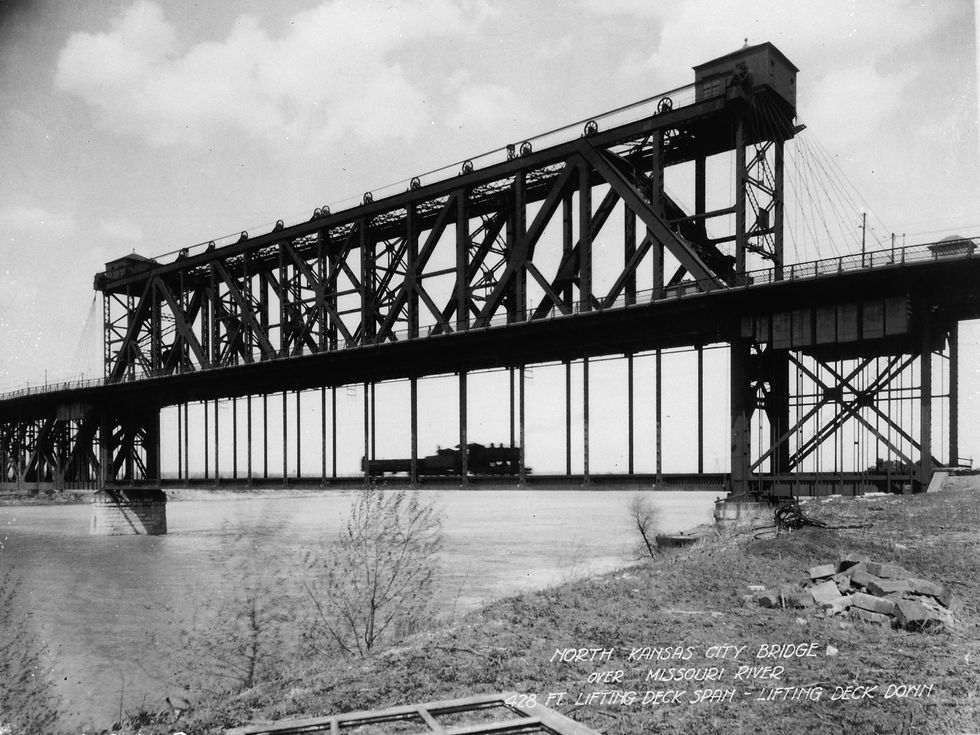 Historic ASB Bridge over the Missouri River in Kansas City, showing its grey steel vertical-lift towers and railroad structure.
