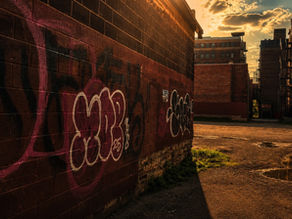 Golden evening light across a graffiti-covered brick alley in Kansas City's West Bottoms.