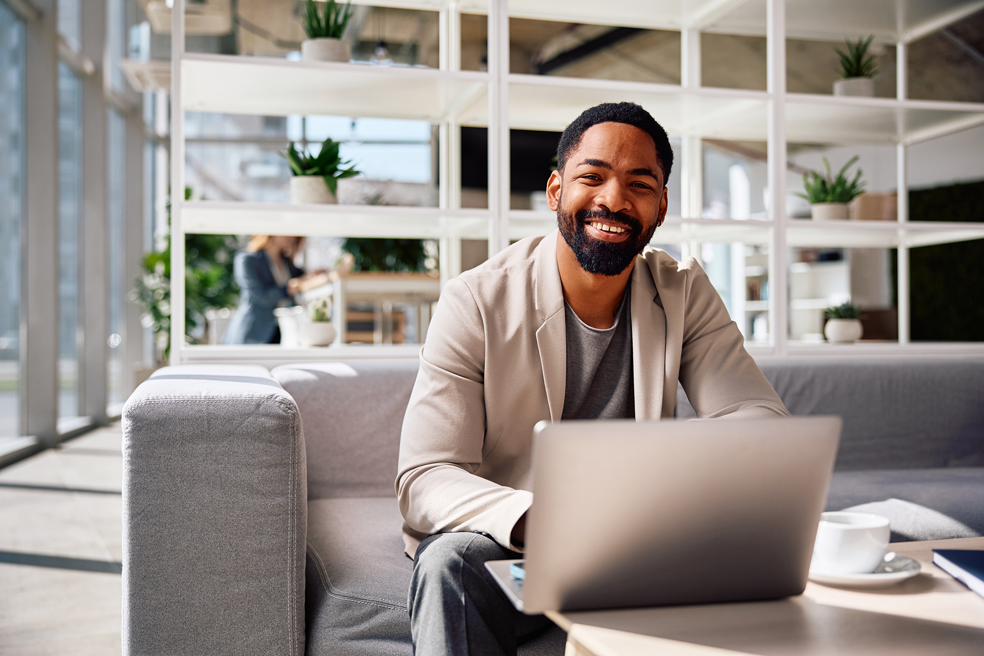 Young man smiling while sitting in an office space after his session with Guided Therapy Co. therapist just ended