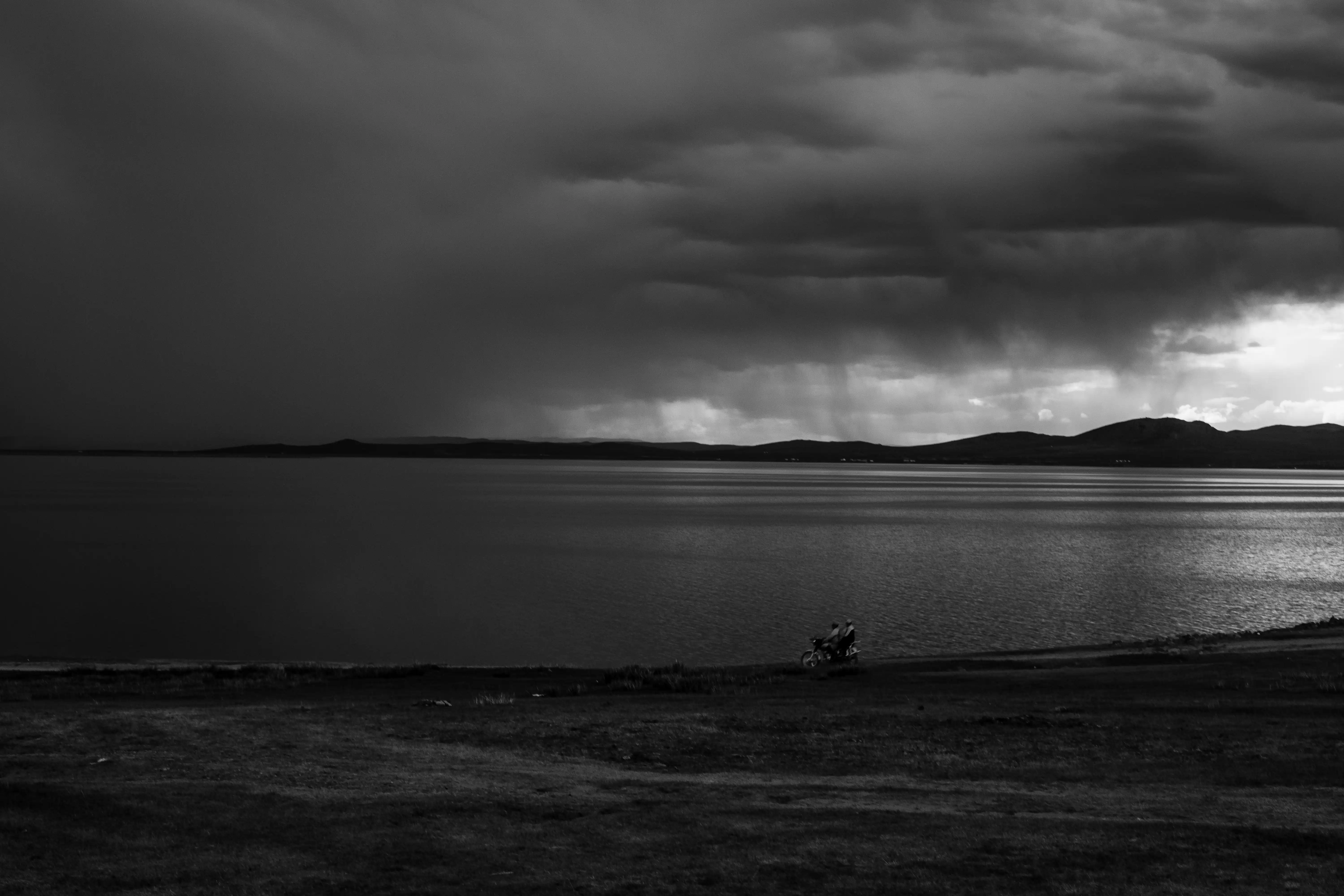 Biker racing against the storm at Ugii Lake in Central Mongolia