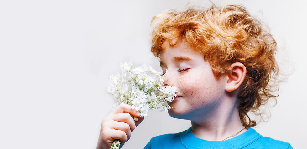 child smelling a flower