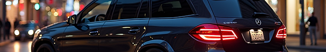 A sleek, customized SUV with tinted windows and subtle underglow lighting parked in a vibr