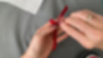 Hands peeling the plastic off heat transfer vinyl ironed onto a ribbon made of red velvet ribbon.