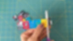 Hands using scissors to cut apart book covers printed on sticker paper.