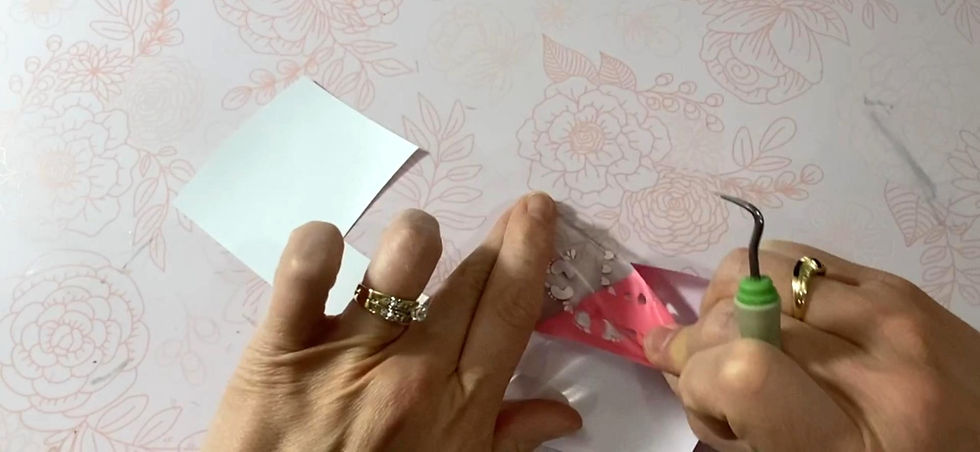 A Cricut weeding tool being used to remove unwanted heat transfer vinyl from a Cricut cut design.