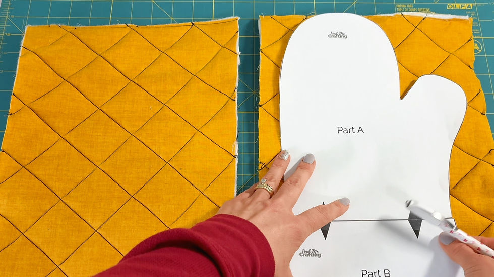 Hands aligning an oven mitt pattern on quilted yellow fabric with a grid pattern, against a teal cutting mat. Text reads "Part A" and "Find Me Crafting."
