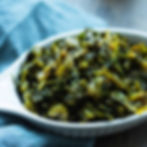 Eye-level view of a basket filled with fresh callaloo and other leafy greens