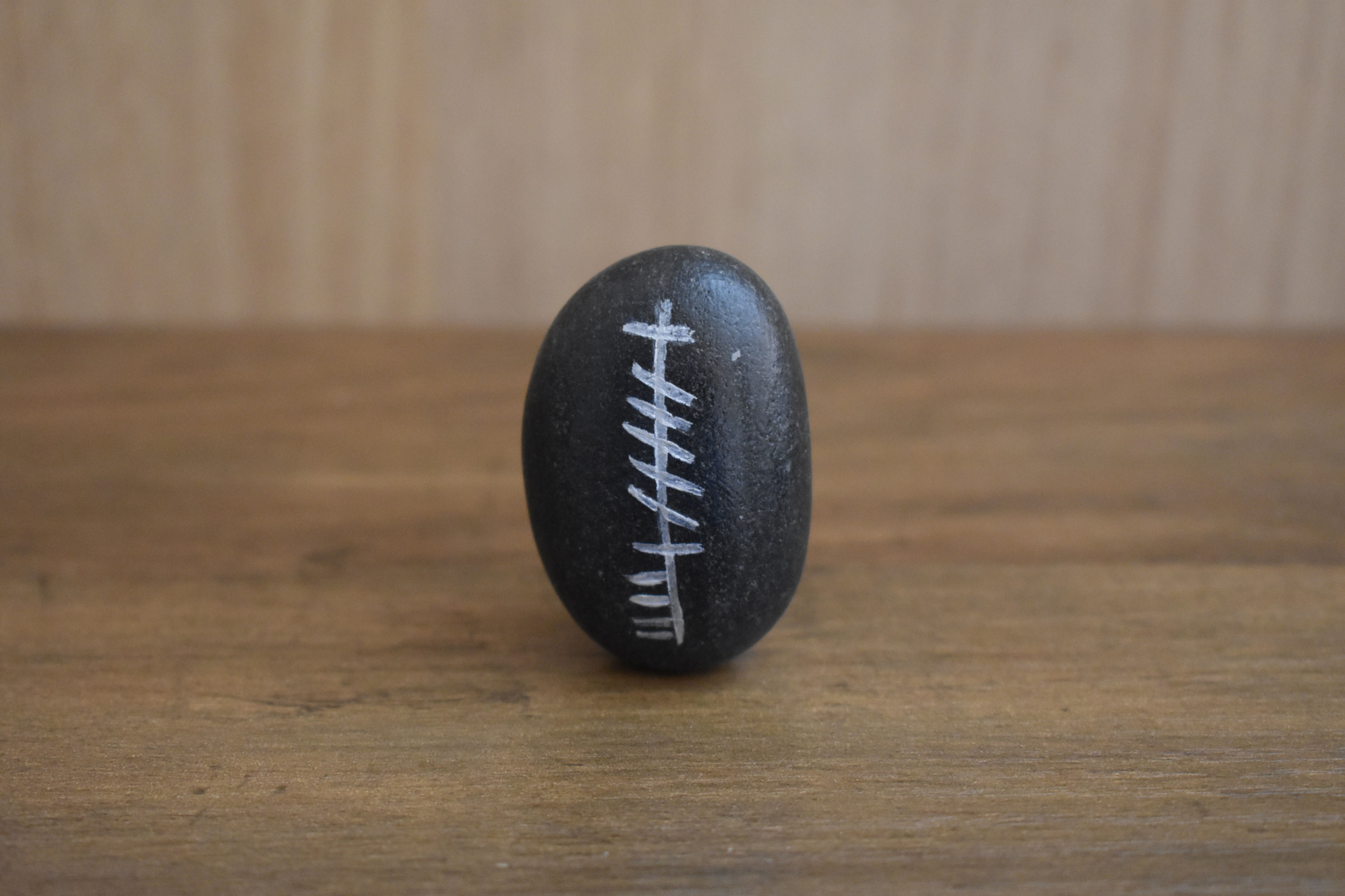 Cara (Friend) Ogham stone on wooden surface