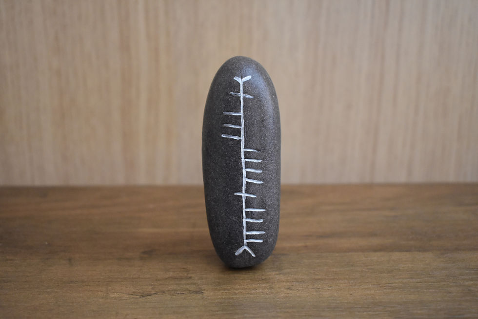 Smooth oval stone with Ogham script for Sásta Happy
