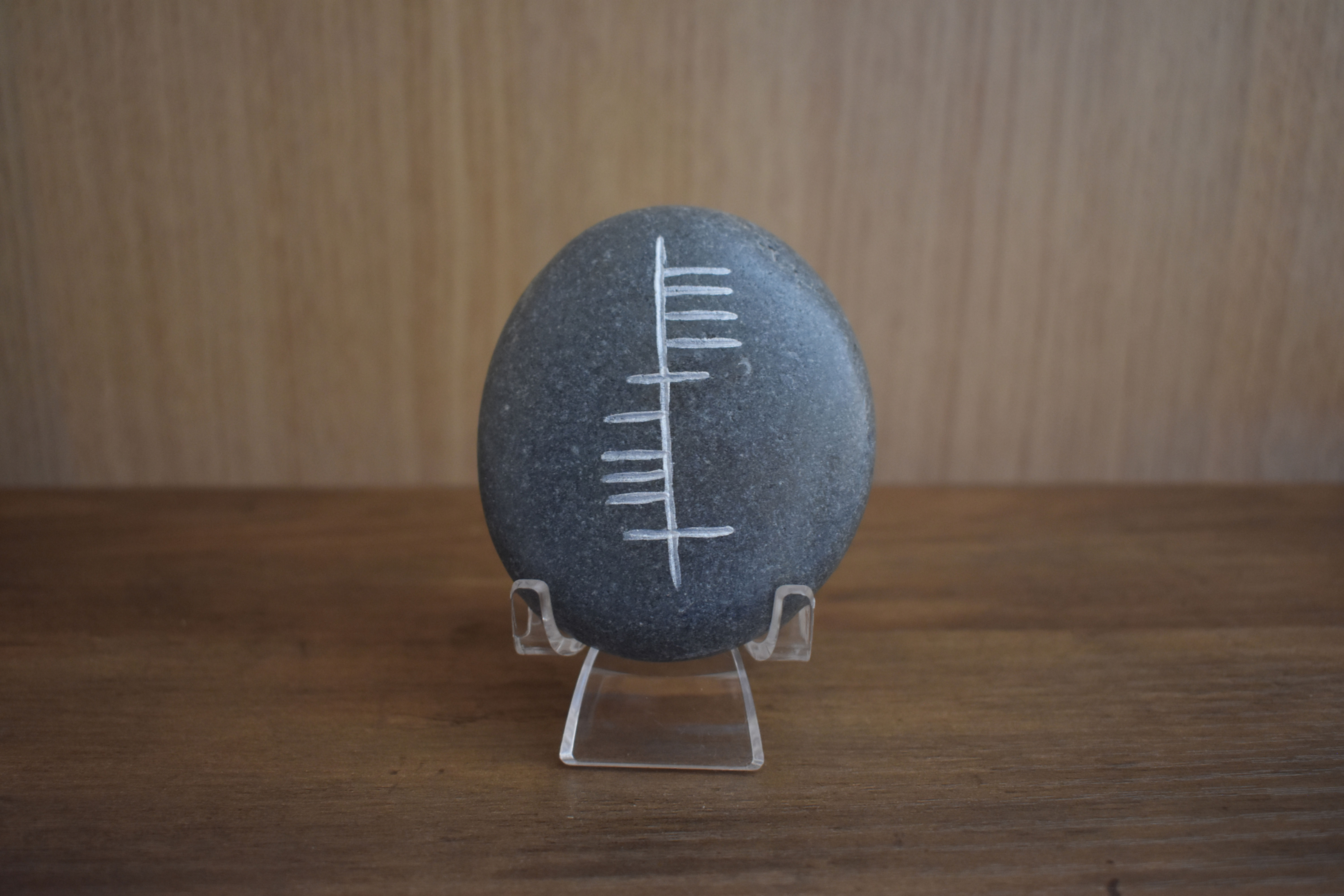 Ogham inscription for Áthas carved on a smooth gray stone