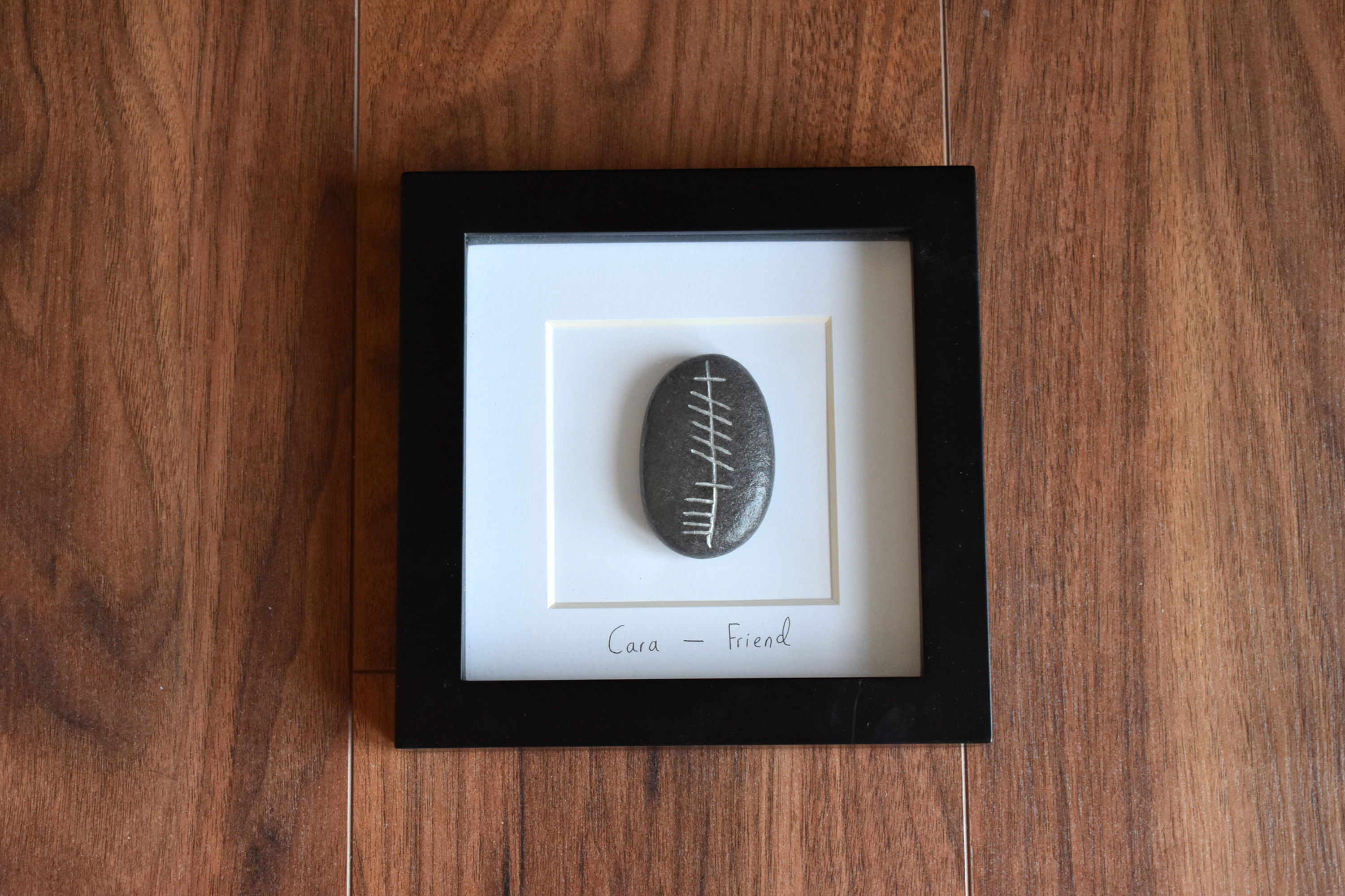 Cara (Friend) Ogham Stone Frame on wooden surface