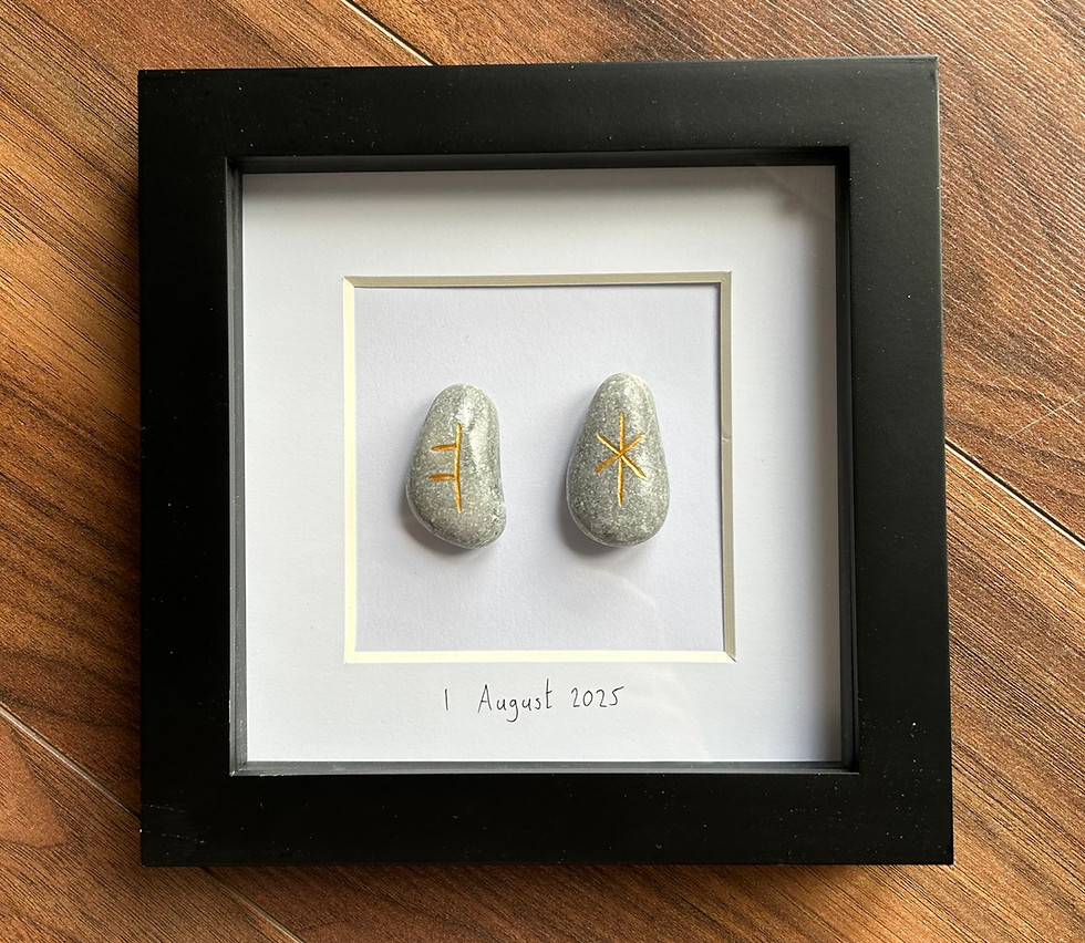 Custom framed pebble art with two stones and script text.
