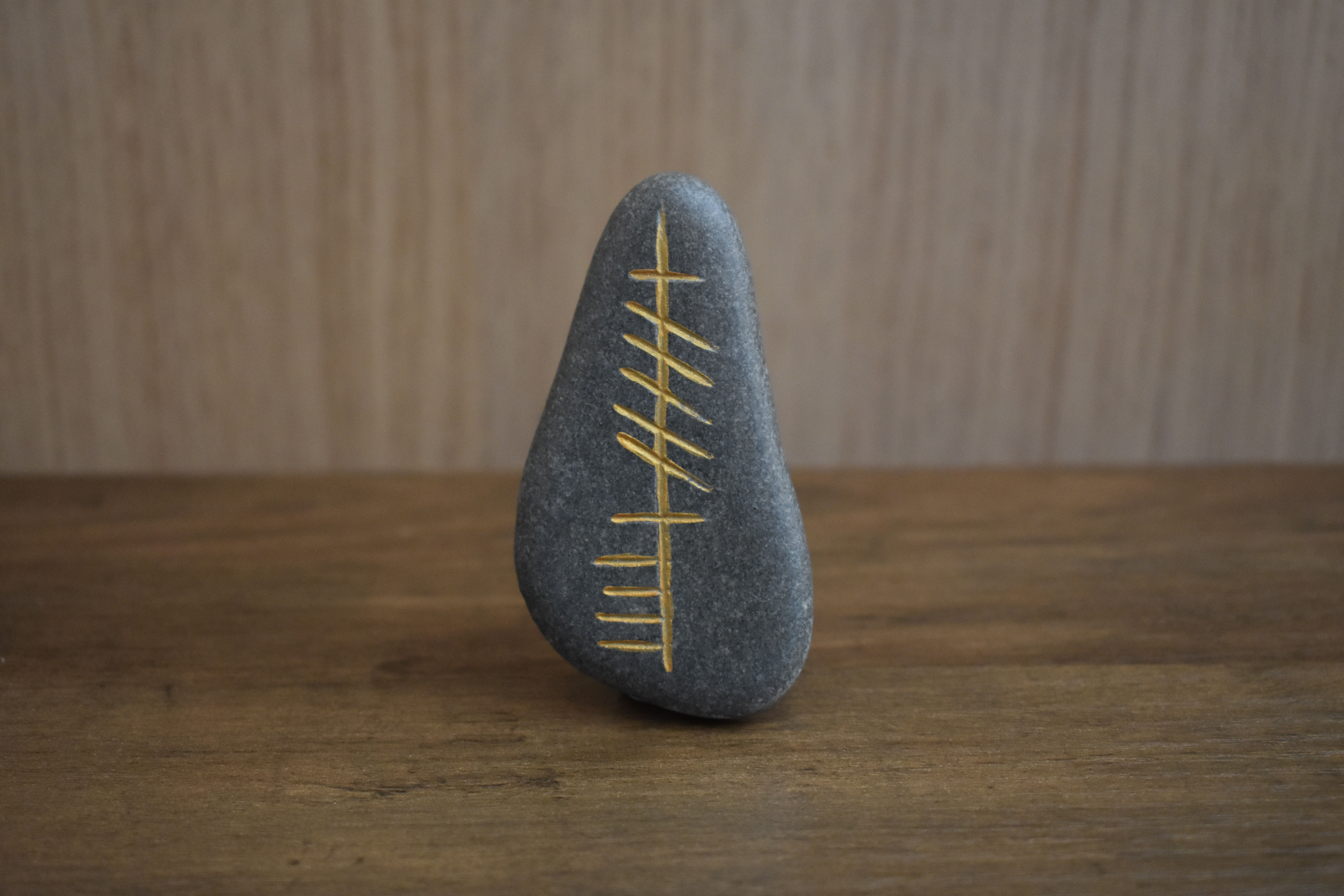 Ogham stone with Cara inscription on a wooden surface