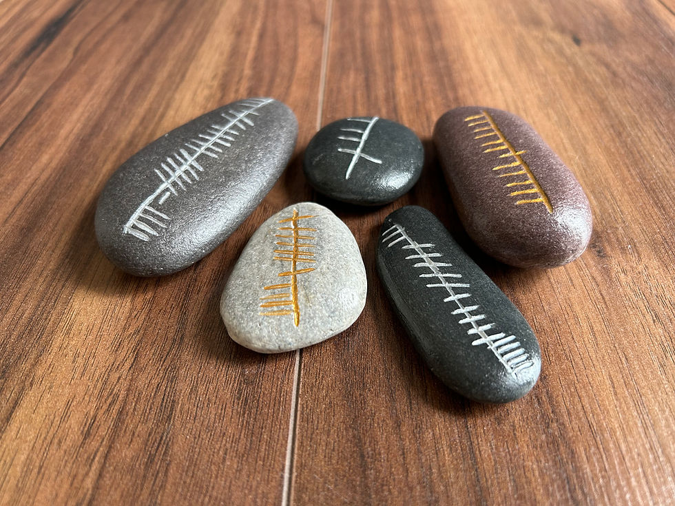 Smooth stones with Ogham inscriptions on a wooden surface.