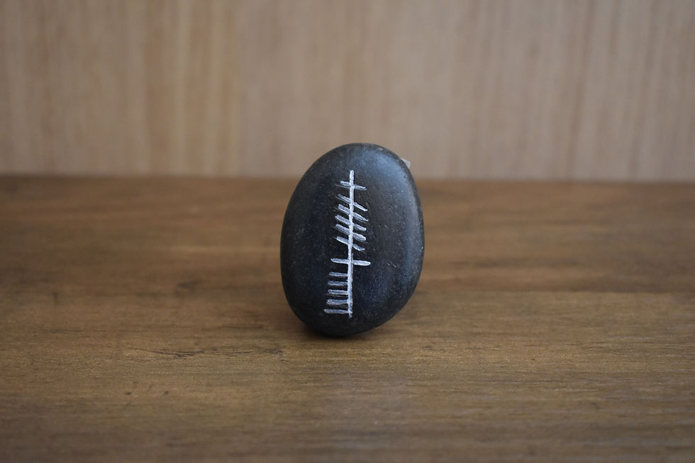 Small black stone with the Ogham word Cara inscribed.