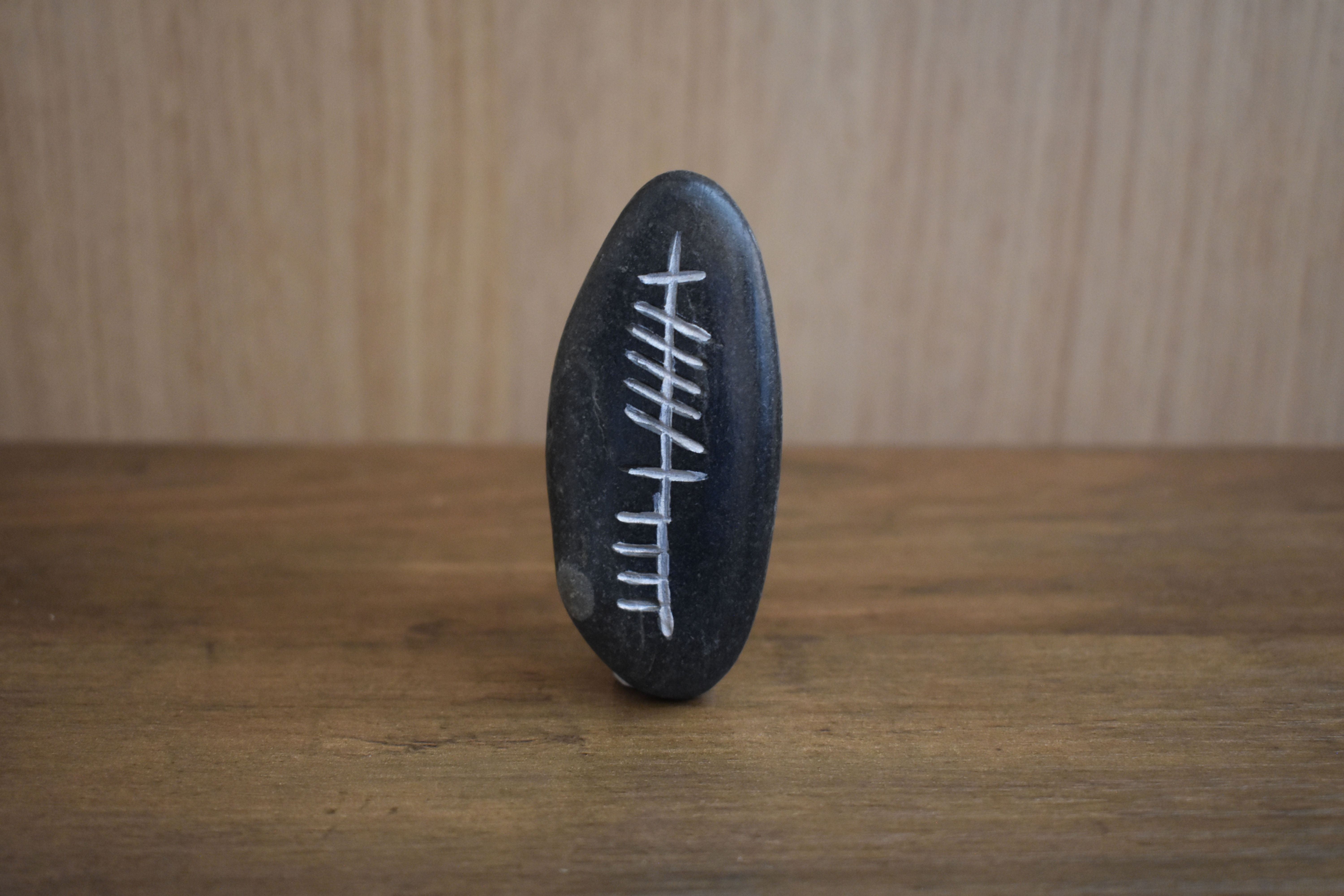 Ogham stone with Cara inscription on a wooden surface